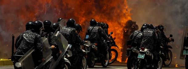 Explosión contra un grupo de policías en Caracas, ayer. Foto: EFE