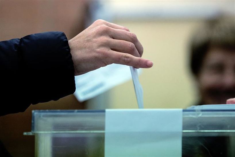 Un ciudadano mete su voto en la urna, bajo la supervisión de la presidenta de la mesa electoral. EFE