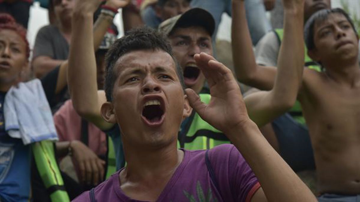 Migrantes centroamericanos apoyan a sus compañeros desde el margen mexicano del río Suchiate / EFE.