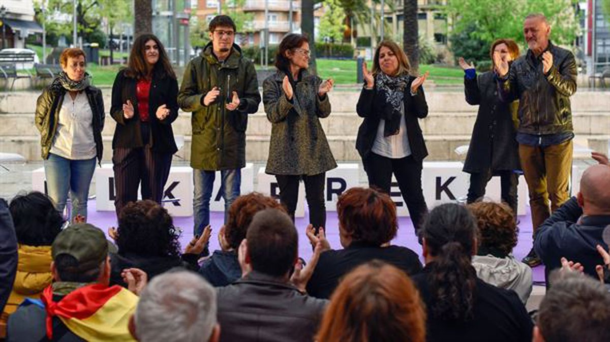 Candidatos de Elkarrekin Podemos aplauden sobre el escenario en un acto de campaña en Santurtzi
