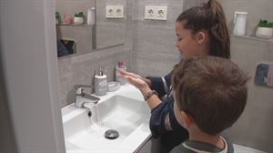 Una mujer limpiandose las manos con un niño