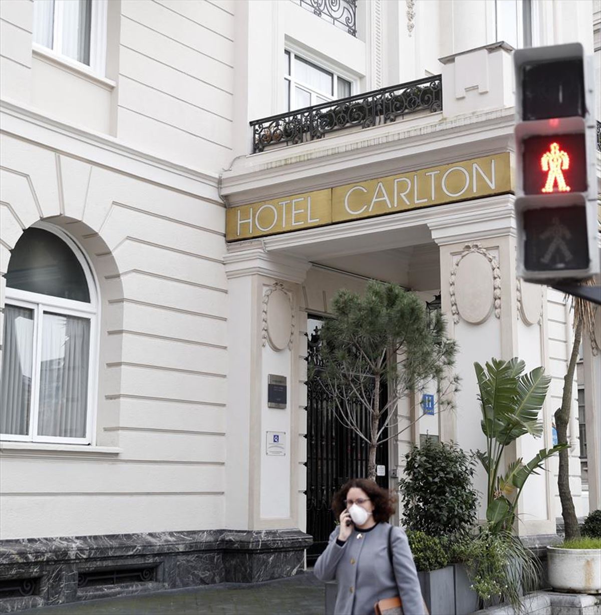 Una mujer con mascarilla camina frente al Hotel Calton de Bilbao.