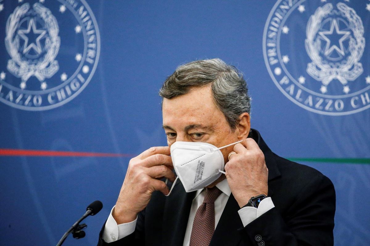 El primer ministro italiano, Mario Draghi, se quita la mascarilla para comparecer ante los medios. 