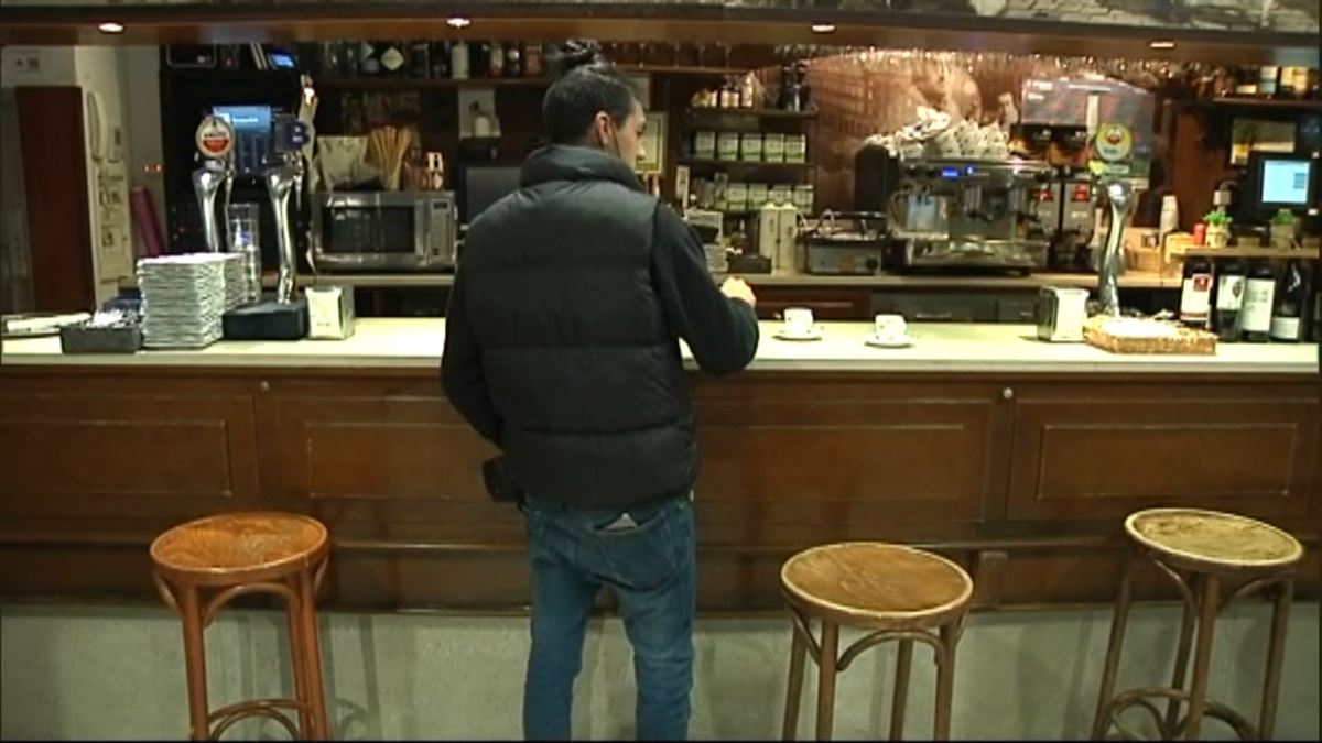 Un cliente, tomando un café en la barra de un bar en Pamplona. 