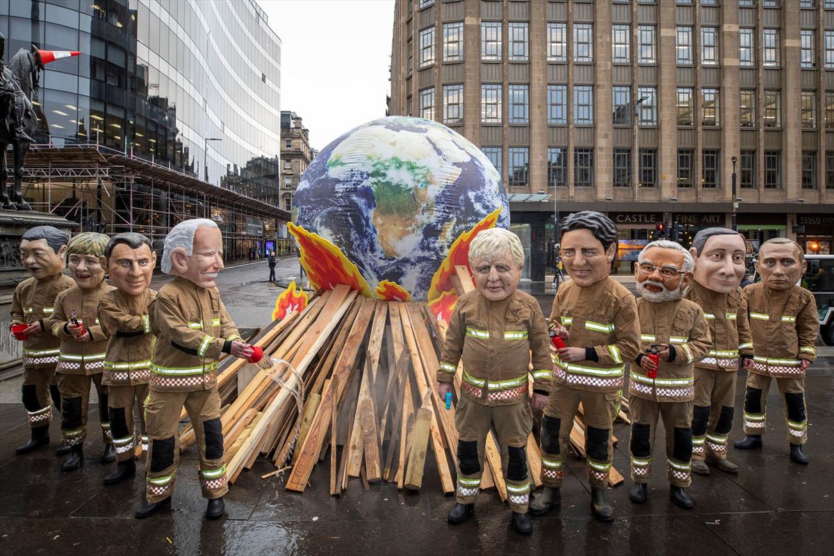 Activistas posan como líderes mundiales disfrazados de bomberos en Glasgow (Escocia). Foto: EFE