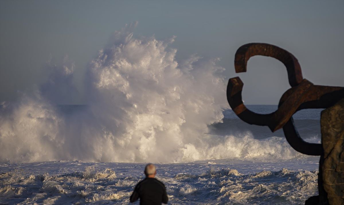 Un hombre en el Peine de los vientos de San Sebastián, ante grandes olas. 