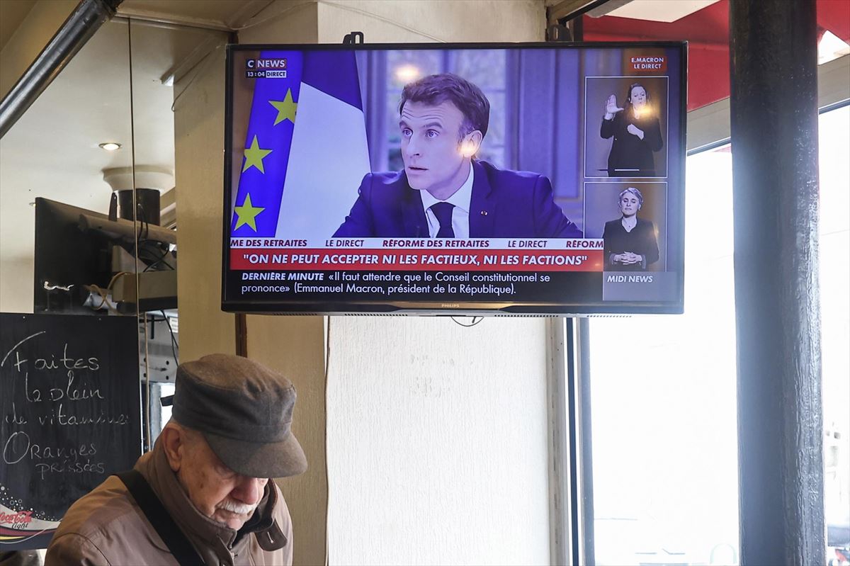 Emmanuel Macron Frantziako presidentea Pariseko taberna bateko telebistan.