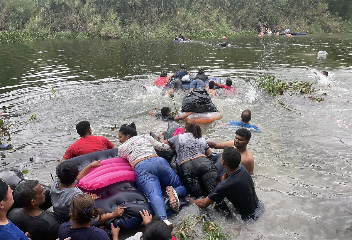 Migrantes Cruzando Rio Bravo entre México y los Estados Unidos. 
