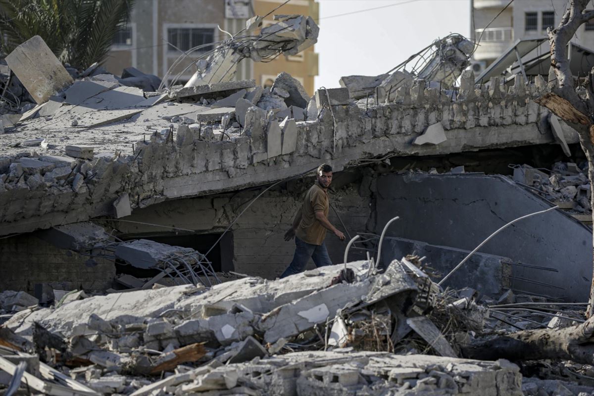 Un hombre busca víctimas entre los escombros de una edificio destruido por las bombas en Gaza. EFE