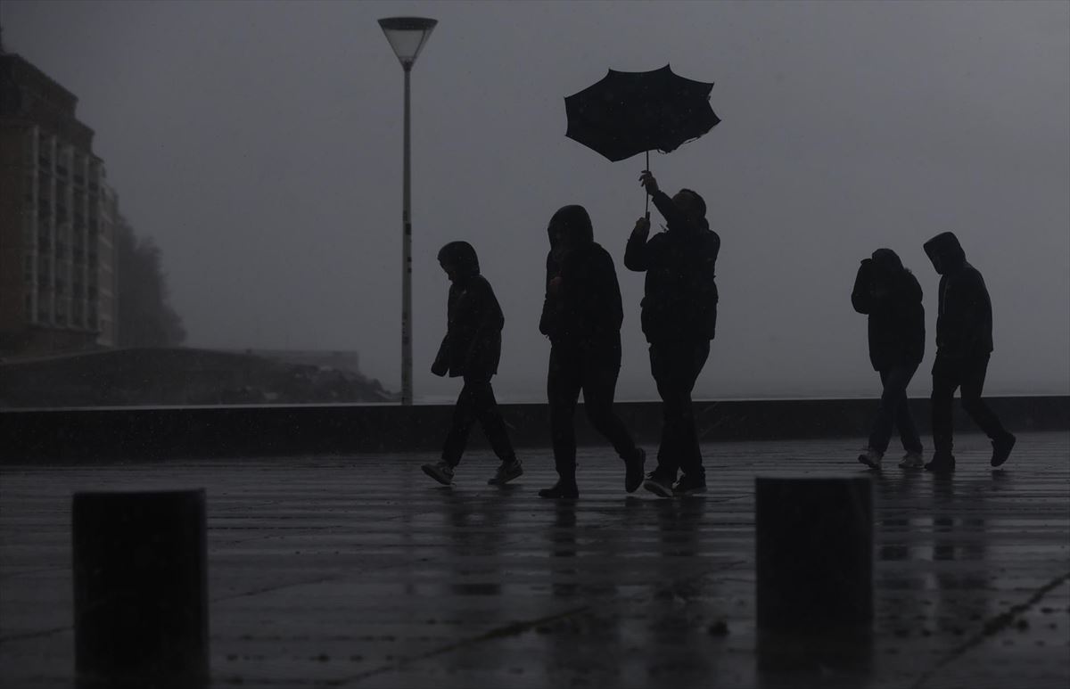 Varias personas bajo la lluvia en San Sebastián. 